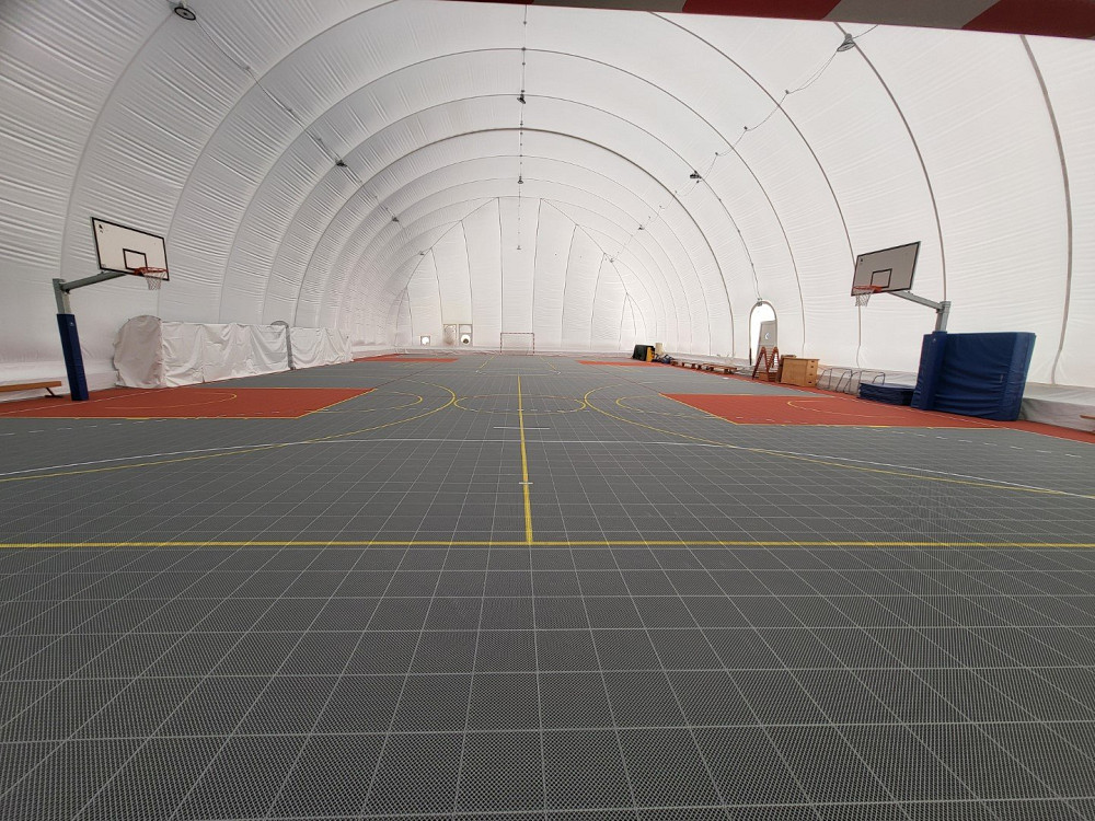 V BALONU NAD ZAČASNO ŠPORTNO DVORANO V BOVCU JE NAMEŠČENA NOVA RECIKLABILNA ŠPORTNA PODLAGA, ki bo po zaključku gradnje uporabljena na zunanjem igrišču.