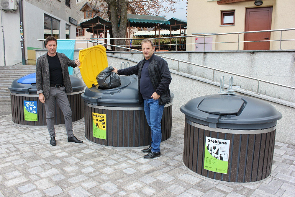 OB URADNI PREDAJI NOVEGA EKOLOŠKEGA OTOKA S POTOPNIMI ZABOJNIKI POD BOVŠKO TRŽNICO sta župan Občine Bovec Valter Mlekuž in direktor Komunale Tolmin Mitja Constantini simbolno odvrgla prvo vrečko odpadkov.